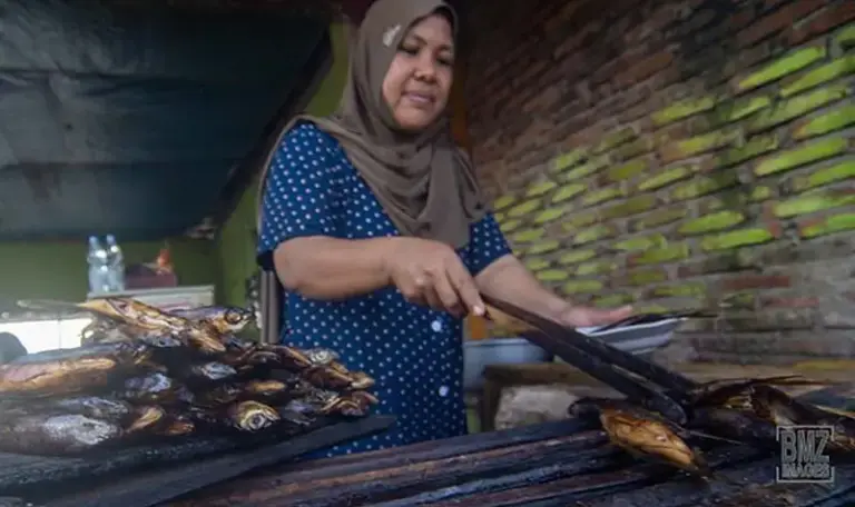 Pedagang menyiapkan ikan "tuing-tuing tapa" atau ikan terbang bakar khas Kabupaten Majene pesanan pembeli di salah satu ruas jalan di Desa Labuan Somba, Kecamtan Cendana, Kabupaten Majene, Sulawesi Barat, Minggu (30/4/2023). bmzIMAGES/Basri Marzuki