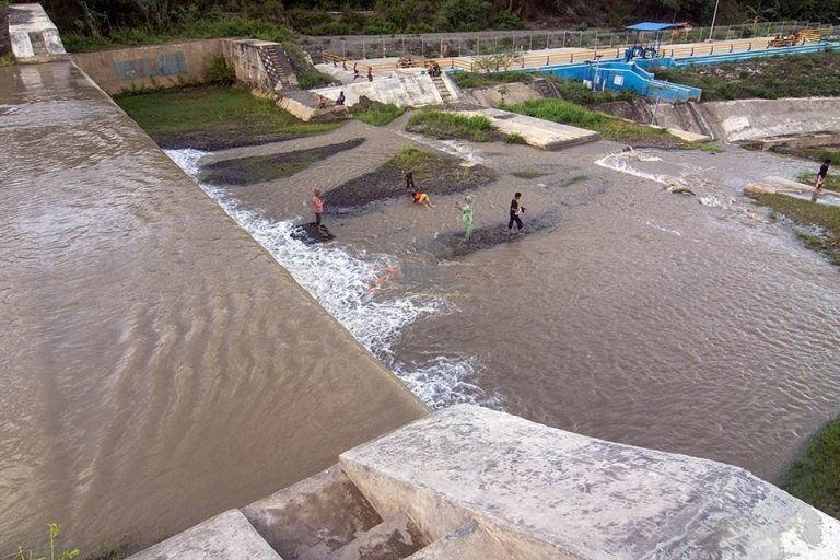 Sejumlah pengunjung bermain air di saluran pembuangan air saat berwisata lebaran di Cek Dam Lawara, Desa Balane, Sigi, Sulawesi Tengah, Jumat (12/4/2024).