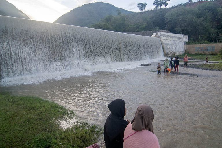 Sejumlah pengunjung bermain air di saluran pembuangan air saat berwisata lebaran di Cek Dam Lawara, Desa Balane, Sigi, Sulawesi Tengah, Jumat (12/4/2024).