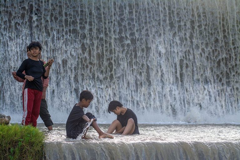 Sejumlah pengunjung bermain air di saluran pembuangan air saat berwisata lebaran di Cek Dam Lawara, Desa Balane, Sigi, Sulawesi Tengah, Jumat (12/4/2024).