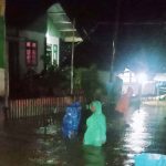 Warga melintasi banjir yang menggenangi pemukiman warga di Desa Talaki, Paleleh, Buol, Minggu (7/4/2024) malam. (Foto: BPBD Sulteng)