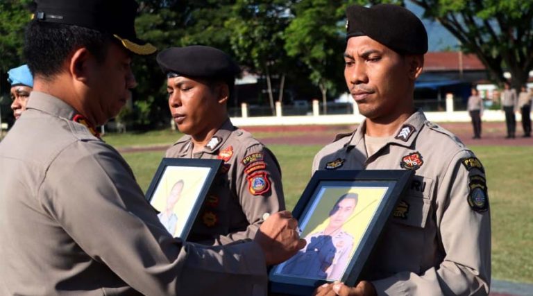 Kapolres Sigi, AKBP Reja Simanjuntak (kiri) mencoret foto personelnya yang dipecat dari intitusi Polri dalam upacara PTDH di Mapolres Sigi, Senin (22/4/2024). (Foto: Humas Polres Sigi)