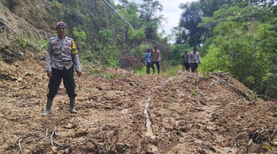 Personel Polsek Kulawi di lokasi longsor di Kecamtan Pipikoro. Mereka harus berjalan kaki untuk menuju desa berikutnya karena jembatan gantung satu-satunya terputus akibat banjir. (Foto: Humas Pores Sigi)