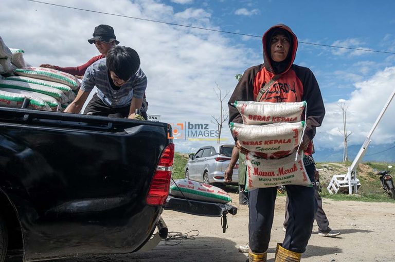Sejumlah pemulung mengangkat beras yang akan dibagikan di kawasan Tempat Pembuangan Akhir (TPA) sampah Kawatuna di Palu, Sulawesi Tengah, Selasa (2/4/2024).