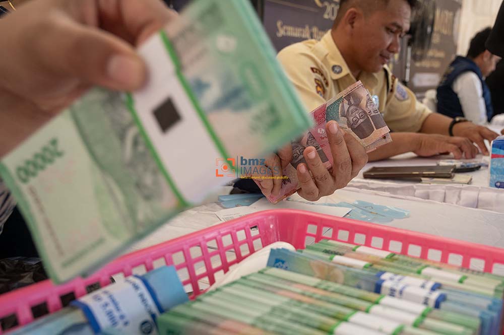 Kartyawan bank menghitung uang warga yang akan ditukarkan dengan pecahan kecil di kawasan layanan bersama penukaran uang di Palu, Sulawesi Tengah, Selasa (2/4/2024). Bank Indonesia Perwakilan Sulteng menginisiasi layanan penukaran uang bersama dengan melibatkan perbankan sebagai tanggapan atas tingginya minat masyarakat menukarkan uangnya menjelang lebaran Idul Fitri 1445 H. bmzIMAGES/Basri Marzuki