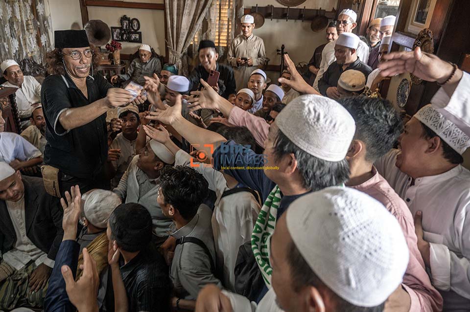 Tuan rumah warga keturunan Arab membagi-bagikan uang pada Lebaran Iwwadh atau Lebaran Arab di Palu, Sulawesi Tengah, Kamis (11/4/2024). Lebaran Iwwadh atau Lebaran Arab adalah tradisi berlebaran yang sudah dilakukan turun temurun di komunitas Arab di wilayah itu dan dilaksanakan di hari kedua Idul Fitri dengan saling mengunjungi sesama keluarga dan komunitas sambil mendoakan dan menyantap makanan bersama dan berbagi rezeki. (bmzIMAGES/Basri Marzuki)