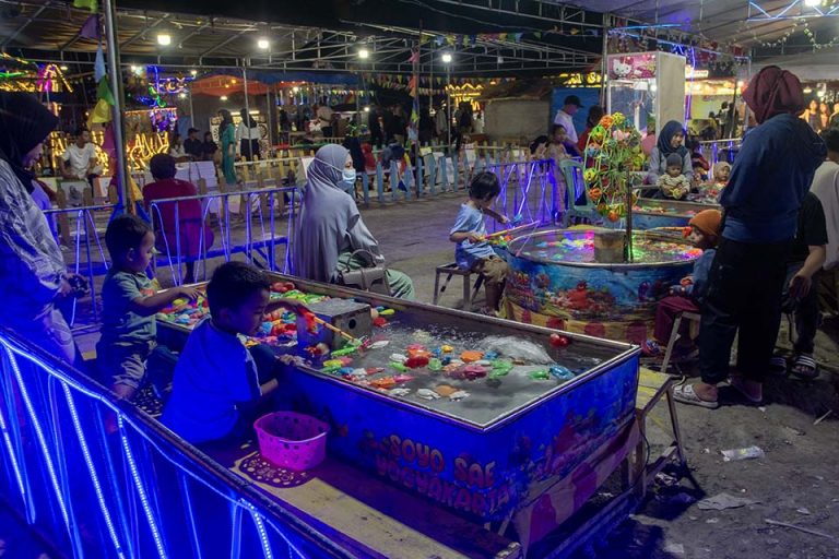 Sejumlah anak menikmati permainan di wahana permainan saat berwisata lebaran di Pasar Malam di Palu, Sulawesi Tengah, Minggu (14/4/2024).