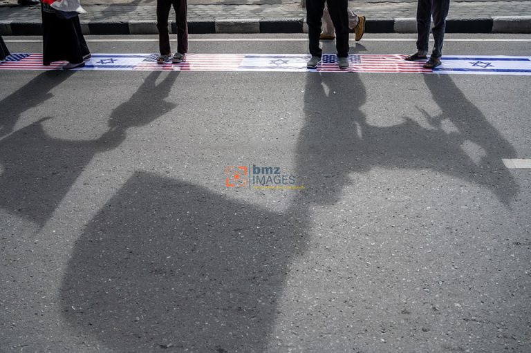 Sejumlah warga yang menamakan diri dari Barisan Aliansi Resistensi Al-Aqsha (Baraq) menggunakan simbol bendera Israel dan Amerika Serikat sebagai alas saat berunjukrasa di Palu, Sulawesi Tengah, Jumat (5/4/2021).