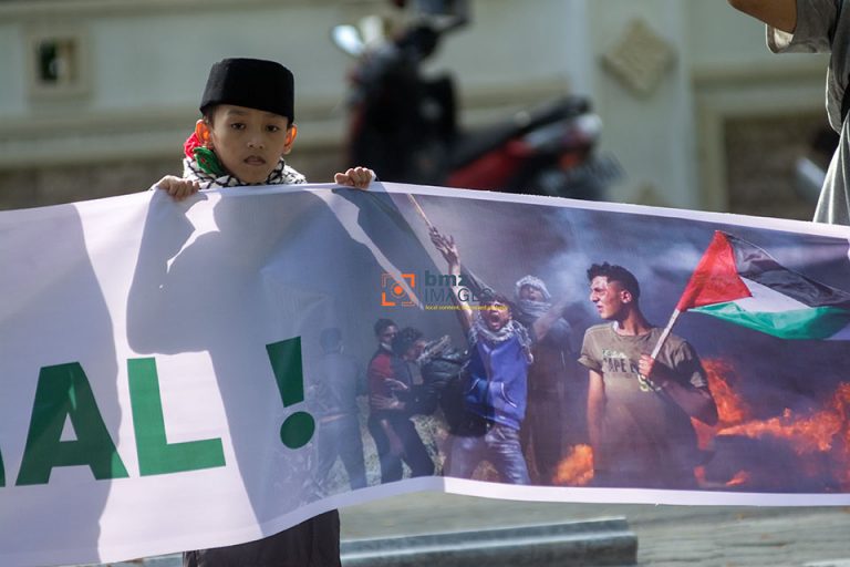 Seorang anak yang yang tergabung dalam Barisan Aliansi Resistensi Al-Aqsha (Baraq) memegang spanduk saat ikut berunjukrasa di Palu, Sulawesi Tengah, Jumat (5/4/2021). Mereka menyerukan penghentian genosida bagi rakyat Palestina, melawan zionisme internasional, dan meminta pemboikotan produk Israel dan juga pendukung genosida di Palestina. bmzIMAGES/Basri Marzuki