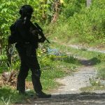 Personel Gegana Brimob Polda Sulteng berjaga di depan sebuah rumah yang sedang digeledah Densus 88 Anti Teror di Desa Kulukubula, Sigi, Sulawesi Tengah, Selasa (16/4/2024). (Foto: bmzIMAGES/Basri Marzuki)