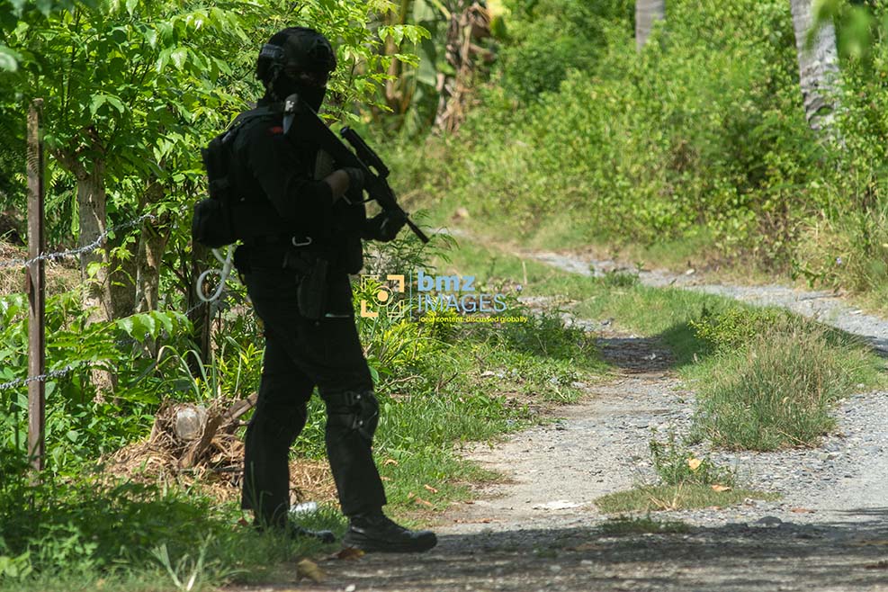 Personel Gegana Brimob Polda Sulteng berjaga di depan sebuah rumah yang sedang digeledah Densus 88 Anti Teror di Desa Kulukubula, Sigi, Sulawesi Tengah, Selasa (16/4/2024). (Foto: bmzIMAGES/Basri Marzuki)