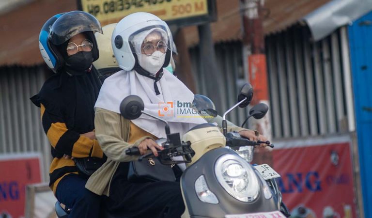 Pengendara sepeda motor mengenakan masker untuk menghindari paparan gas Sulfur Dioksida (SO2) yang telah mencapai status berbahaya hingga sangat berbahaya di Palu, Sulawesi Tengah, Selasa (23/4/2024). (bmzIMAGES/Basri Marzuki)