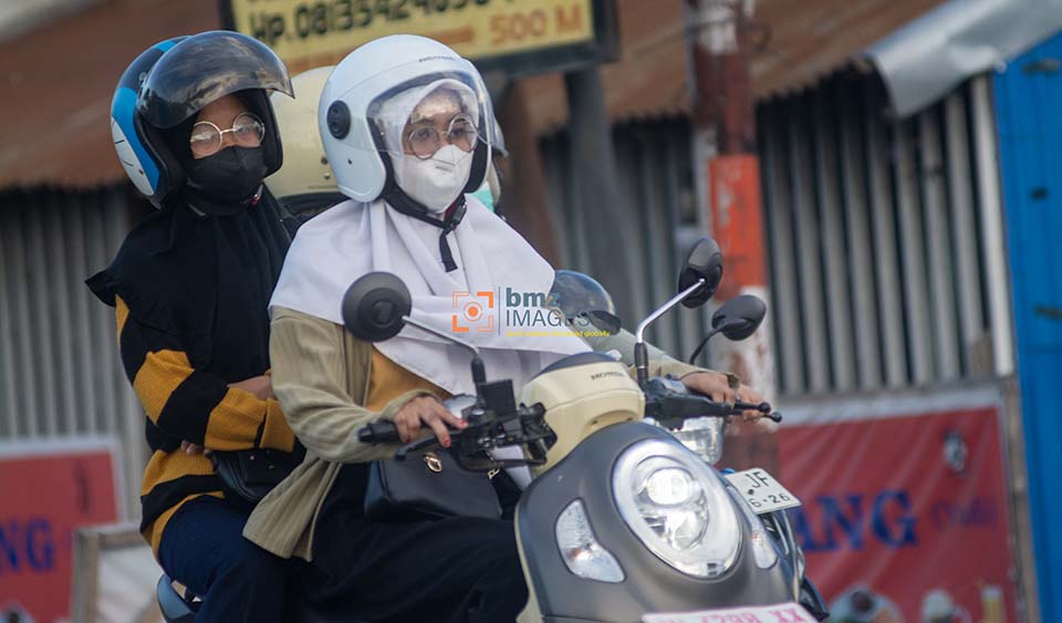 Pengendara sepeda motor mengenakan masker untuk menghindari paparan gas Sulfur Dioksida (SO2) yang telah mencapai status berbahaya hingga sangat berbahaya di Palu, Sulawesi Tengah, Selasa (23/4/2024). (bmzIMAGES/Basri Marzuki)