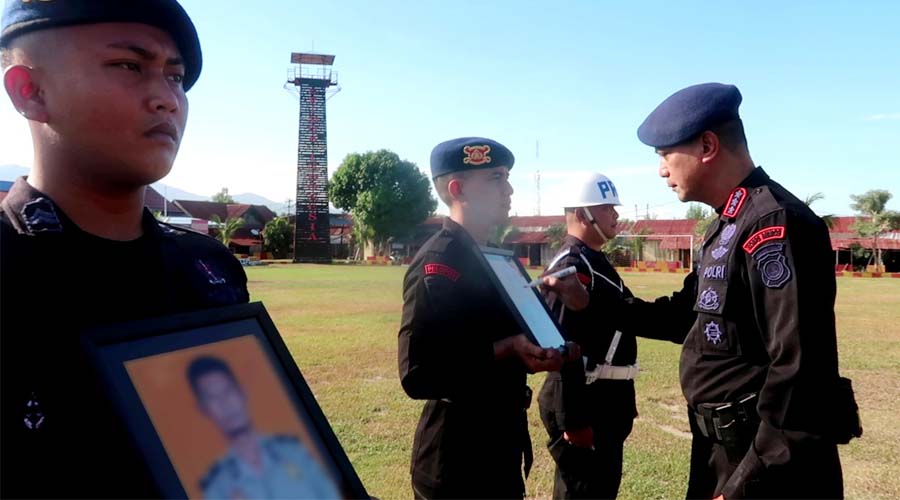 Dansatbrimob Polda Sulteng Kombes Pol. Kurniawan Tandi Rongre mencoret foto dua personel menandai pemecatan kepada keduanya pada upacara PTDH di Mako Brimob Polda Sulteng, Jumat (26/4/2024). (Foto: Humas Polda Sulteng)