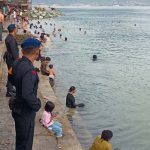 Tim SAR Satgas Operasi Ketupat TInombala memantau warga yang sedang mandi di pantai Kampung Nelayan Palu, Sabtu (13/4/2024). (Foto: Humas Ops Ketupat TInombala)
