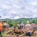 Warga berada di tumpukan kayu pasca banjir bandang di Desa Sibaloga, Kecamatan Tioribulu, Parigi Moutong, MInggu (23/6/2024). (Foto: HO-Basarnas Palu)