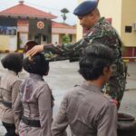 Wadansat Brimob Polda Sulteng AKBP Rentrix Ryaldi Yusuf menyiramkan air bunga kepeada empat personel Bintara Remaja Polwan di Mako Brimob, Kamis (13/6/2024). (Foto: Humas Polda Sulteng)