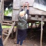 Petugas Pantarlih menempel stiker tanda Coklit di salatu rumah warga di Palu. (Foto: Bawaslu Kota Palu)