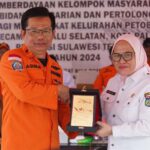 Direktur Bina Potensi kantor Pencarian dan Pertolongan, Agus Haryono (kiri) menyerahkan plakat kepada Sekkto Palu, Irmayanti (kanan) pada penutupan program pemberdayaan masyarakat bidang pencaraian dan pertolongan di Huntap Petobo, Palu, Rabu (31/7/2024). (Foto: Prokopim Setda Kota Palu/Jufri)