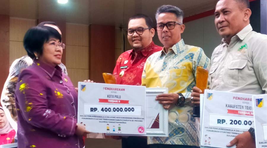 Kepala Bappeda Sulteng menyerahkan penghargaan kepada Kepala Bappeda Kota Palu, Arfan (kedua kanan) atas kinerja pencegahan dan penurunan stunting tahun 2024 tingkat Provinsi Sulawesi Tengah di Palu, Jumat (26/7/2024). (Foto: Ist)