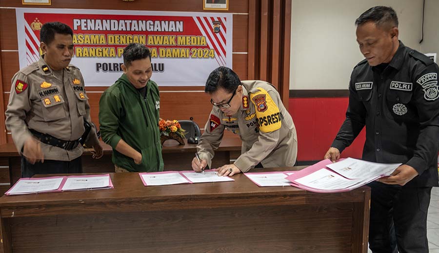 Kapolresta Palu, Kombes Pol Barliansyah (kedua kanan) didampingi PS. Kasubsi PIDM Polresta Palu, Aiptu I Kadek Aruna (kanan) meneken MoU menandai kerjasama dengan media untuk menciptakan suasana yang kondusif pada Pilkada Serentak 2024 di Mapolresta Palu, Selasa (16/7/2024). (Foto: bmz)