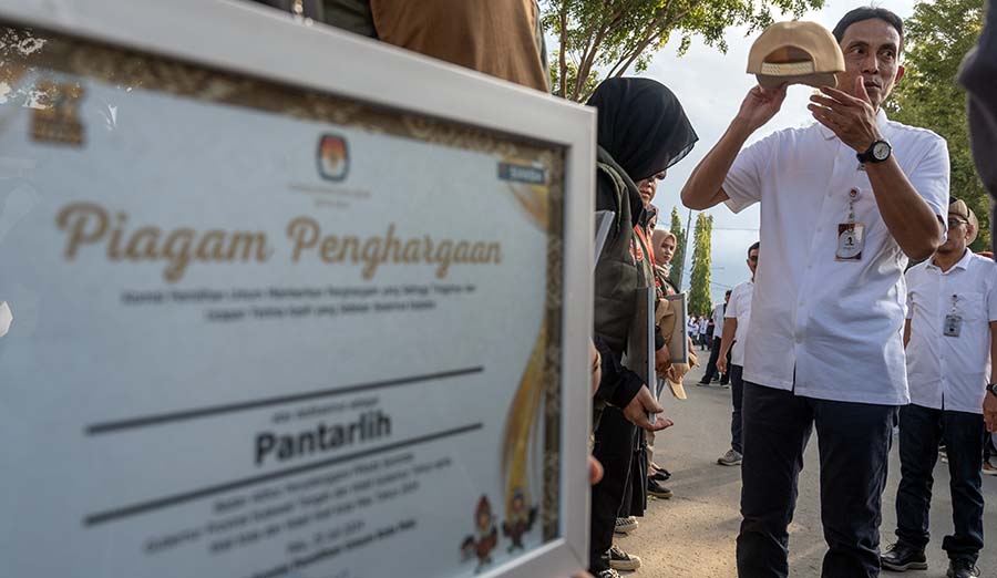 Ketua KPU Kota Palu Idrus (kanan) melepas topi menandai pembubaran petugas Pantarlih pada apel akbar Badan Adhoc di Palu, Sulawesi Tengah, Kamis (25/7/2024). (bmzIMAGES/basrimarzuki)