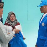 Wali Kota Palu diwakili Asisten Bidang Pemerintahan dan Kesra Setda Kota Palu, Usman (kiri) bersiap mengenakan jaket ke mahasiswa peserta KKN Angkatan XXIV STIAP Pembangunan Palu, Sabtu (6/7/2024). (Foto: Prokopim Sekkot Palu/Iwan)