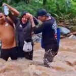 Komisioner KPU Palu, M Musbah menyeberangi sungai untuk mencapai Dusun Uventumbu dan Valiri, Kelurahan Kawatuna dalam rangka monitoring Coklit, Minggu (7/7/2024). (Foto: Tangkapan layar video KPU Kota Palu)