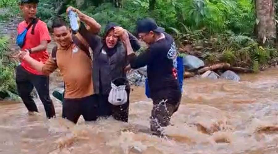 Komisioner KPU Palu, M Musbah menyeberangi sungai untuk mencapai Dusun Uventumbu dan Valiri, Kelurahan Kawatuna dalam rangka monitoring Coklit, Minggu (7/7/2024). (Foto: Tangkapan layar video KPU Kota Palu)
