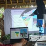 Pemaparan hasil penelitian singkat sampel air dari Danau Poso tentang pencemaran mikroplastik pada workshop Saya Pilih Bumi: Tolak Plastik Sekali Pakau di Dodoha, Musintuwu, Poso, Kamis (11/7/2024). (Foto: Isntitut Mosintuwu)