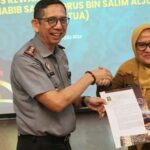 Kakanwil Kemenkumham Sulteng Hermansyah Siregar (kiri) menyerahkan surat pengesahan status WNI Guru Tua kepad aSekkot Palu, Irmayanti Pettalolo di Palu, Senin (29/7/2024). (Foto: Prokopim Setda Kota Palu./Yusuf)