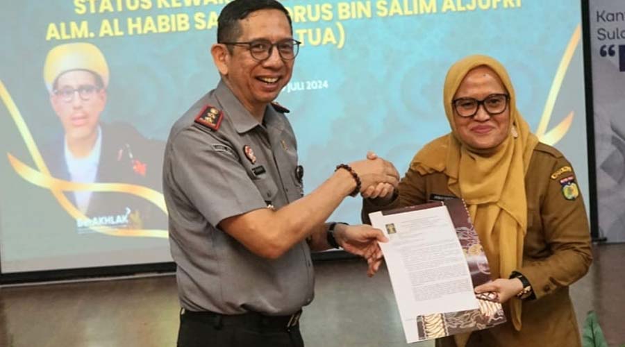 Kakanwil Kemenkumham Sulteng Hermansyah Siregar (kiri) menyerahkan surat pengesahan status WNI Guru Tua kepad aSekkot Palu, Irmayanti Pettalolo di Palu, Senin (29/7/2024). (Foto: Prokopim Setda Kota Palu./Yusuf)