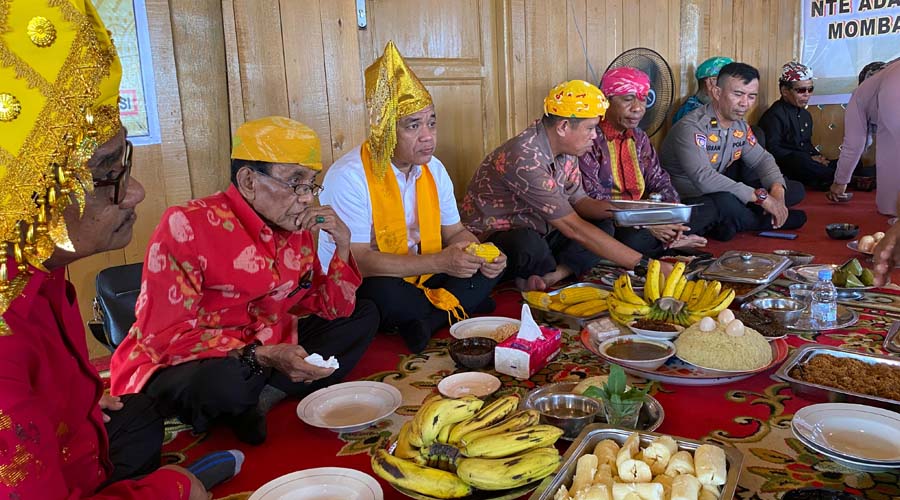 Wali Kota Palu, Hadianto Rasyid (ketiga kiri) mengikuti prosesi makan bersama usai meresmikan rmah adat Kaili di Kelurahan Tipo, Ulujadi, Kota Palu, Minggu (28/7/2024). (Foto: Prokopim Setda Kota Palu/Qadri)
