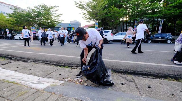 Seorang peserta jalan santai memungut sampah pada Sinergi Lestari PT Vale di Makassar, Minggu (28/7/2024). (Foto: PT Vale)