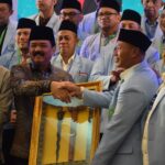 Menko Polhukam Hadi Tjahjanto menyerahkan piagam pengahrgaan kepada Ketua BKPRMI Kota Palu, Daud Usroh atas dedikasi dan pengabdian pada BKPRMI pada Munas XIV BPRKMI di Medan, SUmut, Kamis (8/8/2024). (Foto: Imron)