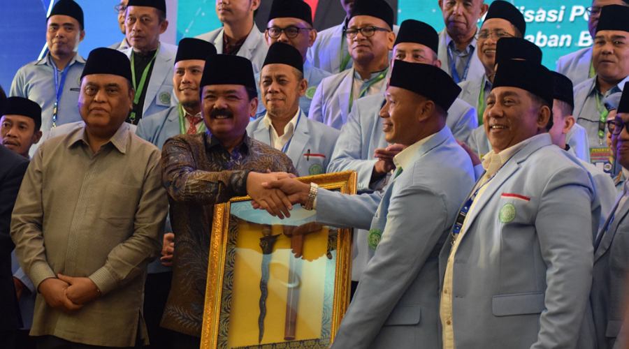 Menko Polhukam Hadi Tjahjanto menyerahkan piagam pengahrgaan kepada Ketua BKPRMI Kota Palu, Daud Usroh atas dedikasi dan pengabdian pada BKPRMI pada Munas XIV BPRKMI di Medan, SUmut, Kamis (8/8/2024). (Foto: Imron)