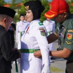Wali Kota Palu Hadianto Rasyid (kiri) mengukuhkan Paskibraka Kota Palu 2024 di Taman Nasional Palu, Jumat (16/8/2024). (Foto: Porkopimda Setda Kota Palu/Iwan)