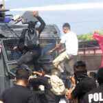 Sejumlah pengunjuk rasa memanjat kendaraan aparat pada simulasi pengamanan kota oleh Polda Sulteng, Kamis (15/8/2024). (Foto: umas Podla Sulteng)