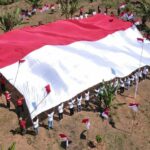 Pembentangan bendera Merah Putih oleh mantan Napiter bersam Satgas Madago raya di Gunung Biru, Kabupaten Poso, Jumat (16/8/2024). (Foto: HO-Satgas Madago Raya)