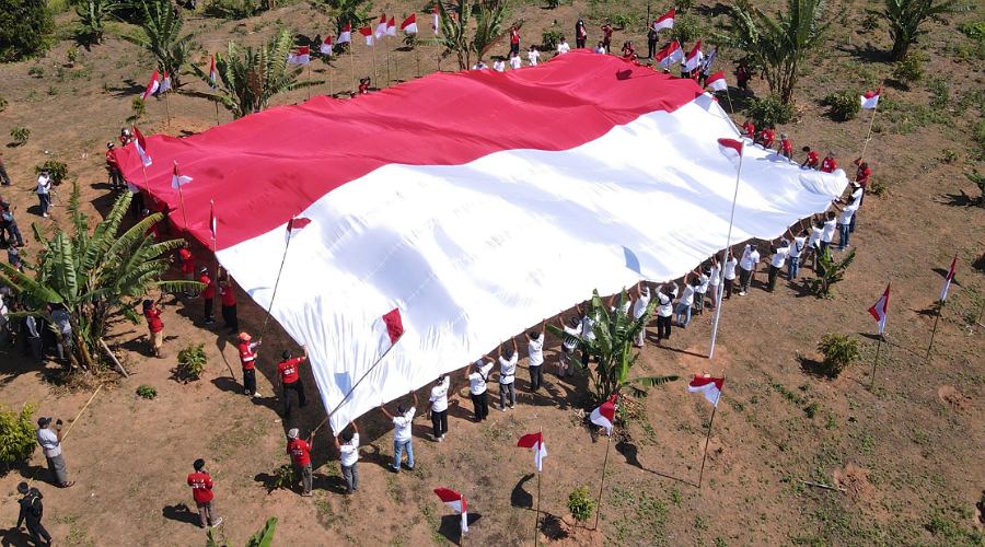 Pembentangan bendera Merah Putih oleh mantan Napiter bersam Satgas Madago raya di Gunung Biru, Kabupaten Poso, Jumat (16/8/2024). (Foto: HO-Satgas Madago Raya)