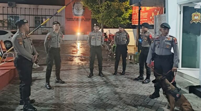 Sejumlah polisi dibantu seekor anjing pelacak berada d Kantor KPU Sulteng, Minggu (25/8/2024). Foto: Humas Polda Sulteng