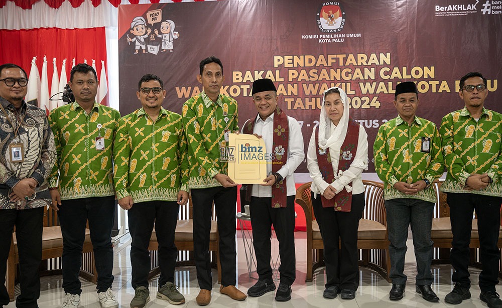 Ketua KPU Kota Palu, Idrus (keempat kiri) bersama komisioner KPU Kota Palu disaksikan Ketua Bawaslu Kota Palu, AGussalim Wahid (kiri) menyerahkan berita acara penerimaan pendaftaran kepada bakal calon Wali Kota Palu, Hadianto Rasyid (keempat kanan) dan bakal calon Wakil Wali Kota Palu, Imleda Liliana Muhidin (ketiga kanan) di Kantor KPU Kota Palu, Kamis (29/8/2024). (Foto: bmzIMAGES/Basri Marzuki)