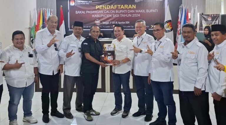 Ketua KPU Sigi, Soleman (keempat kiri) menyerahkan cinderamata kepada Moh Irwan Lapata selaku Ketua Tim Pemenangan pasangan Rizal Intjenae-Samuel Yansen Pongi usai mendaftar di KPU Sigi, Rabu (28/8/2024). (Foto: ist)