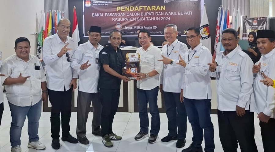 Ketua KPU Sigi, Soleman (keempat kiri) menyerahkan cinderamata kepada Moh Irwan Lapata selaku Ketua Tim Pemenangan pasangan Rizal Intjenae-Samuel Yansen Pongi usai mendaftar di KPU Sigi, Rabu (28/8/2024). (Foto: ist)