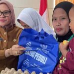 Sekkot Palu, Irmayanti (kiri) menyerahkan zakat kepada salah seorang warga penerima di Kantor Kecamatan Tatanga, Palu, Selasa (13/8/2024); (Foto: Porkopimda Setda Kota Palu/Jufri)