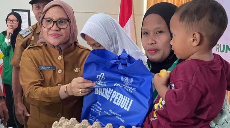 Sekkot Palu, Irmayanti (kiri) menyerahkan zakat kepada salah seorang warga penerima di Kantor Kecamatan Tatanga, Palu, Selasa (13/8/2024); (Foto: Porkopimda Setda Kota Palu/Jufri)