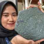 Seorang perempuan menunjukkan paving blok hasil daur ulang sampah plastik saat diluncurkan di Palu, Sabtu (10/8/2024). (Foto: bmzIMAGES/Basri Marzuki)