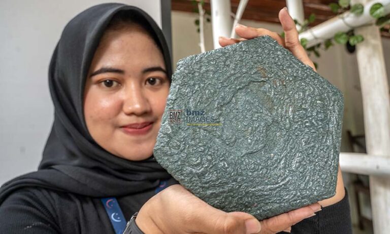 Seorang perempuan menunjukkan paving blok hasil daur ulang sampah plastik saat diluncurkan di Palu, Sabtu (10/8/2024). (Foto: bmzIMAGES/Basri Marzuki)