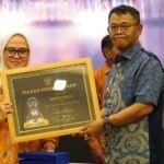 Gubernur Sulteng Rusdy Mastura (kanan) menyerahkan piagam penghargaan kepada Sekkot Palu, Irmayanti atas keberhasilan Pemkot Palu dalam program BPJS-Tenaga Kerja tingkat Sulteng di Palu, Kamis (29/8/2024). (Foto: Prokopim Setda Kota Palu/Jufri)
