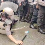Seorang polisi terjatuh saat melakukan mengamankan aksi unjuk rasa pada simulasi sistem pengamanan kota dalam rangka pilkada serentak oleh Polresta Palu di Palu, Kamis (22/8/2024). (Foto: Humas Polresta Palu)